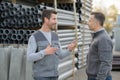 2 male coleagues chatting at pipe factory yard Royalty Free Stock Photo