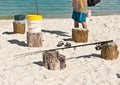 Male collecting fishing gear resting on wood pilings on a sandy, tropical beach on the Gulf of Mexico