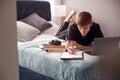 Male College Student Lies On Bed In Shared House Working On Laptop Royalty Free Stock Photo