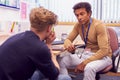 Male College Student Meeting With Campus Counselor Discussing Mental Health Issues