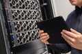 Male Computer Engineer With Digital Tablet Examining Hardware in Datacenter