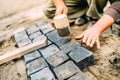 Construction worker using granite cobblestone blocks to create path or sidewalk