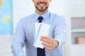 Male consultant holding tickets in travel agency