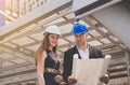Male consultative woman architect working together while standing on building site