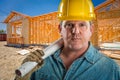 Male Contractor in Hard Hat Holding Floor Plans At Construction Site Royalty Free Stock Photo