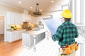 Male Contractor with Hard Hat and Plans Looking At Custom Kitchen Royalty Free Stock Photo