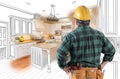 Male Contractor in Hard Hat and Tool Belt Looking At Custom Kitchen Royalty Free Stock Photo