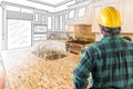 Male Contractor with Hard Hat and Tool Belt Looking At Custom Kitchen Drawing Photo Combination On White. Royalty Free Stock Photo