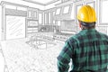 Male Contractor in Hard Hat and Tool Belt Looking At Drawn Custom Kitchen Royalty Free Stock Photo