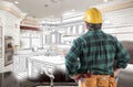 Male Contractor in Hard Hat, Tool Belt Looks At Custom Kitchen Royalty Free Stock Photo