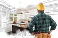 Male Contractor with Hard Hat, Tool Belt Looks at Kitchen Design Royalty Free Stock Photo