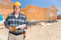 Helpful Male Contractor With House Plans Wearing Hard Hat In Front of Ne Royalty Free Stock Photo