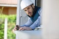 male contractor using tape measure on window sill Royalty Free Stock Photo