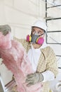 Male contractor wearing dust mask while holding sponge at construction site Royalty Free Stock Photo