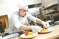 Male cook chef decorating food on the plate Royalty Free Stock Photo