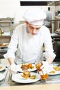 Male cook chef decorating food on the plate Royalty Free Stock Photo