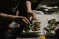 Male cook chef decorating garnishing prepared salad dish on the plate in restaurant commercial kitchen Royalty Free Stock Photo