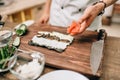 Male cook making sushi on wooden table, asian food Royalty Free Stock Photo
