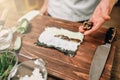 Male cook making sushi on wooden table, seafood