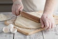 Male cook rolling out dough on the table, closeup shot Royalty Free Stock Photo