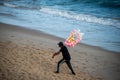 Male cotton candy seller walking on the sand of Farol da Barra beach in Salvador, Bahia state,Brazil