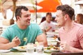 Male Couple Enjoying Lunch In Outdoor Restaurant Royalty Free Stock Photo