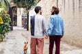 male couple smiling happy walking with their dog Royalty Free Stock Photo