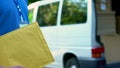 Male courier holding package with documents, postal service, express delivery