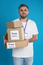 Male courier holding parcels with stickers Free Delivery