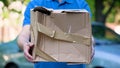 Male courier showing damaged box, cheap parcel delivery, poor shipment quality Royalty Free Stock Photo