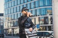 Male courier with sunglasses drinking water when delivering packages in city. Royalty Free Stock Photo