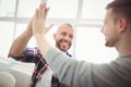 Male coworkers giving high-five