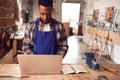 Male Craftsman In Carpentry Workshop For Bamboo Bicycles  Doing Accounts On Laptop Royalty Free Stock Photo