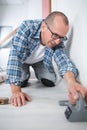 Male craftsman fitting carpet on floor Royalty Free Stock Photo