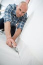 male craftsman fitting carpet on floor Royalty Free Stock Photo