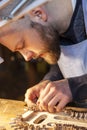 Male craftsman violin maker working on a new violin