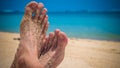 Male Cross Feet at the Sandy Beach, Ocean in Background, Bali