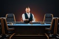 Male croupier at the poker table, poker room. Poker game, casino, Texas hold`em, online game, card games. Modern design, magazine Royalty Free Stock Photo