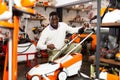 Male customer examining lawnmowers in equipment shop Royalty Free Stock Photo