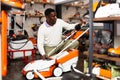 Male customer examining lawnmowers in equipment shop Royalty Free Stock Photo