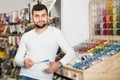 male customer examining various types of brushes in paint store Royalty Free Stock Photo