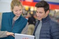 Male customer showing digital tablet to female vendor