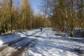 A male cyclist riding along a snow covered countryside road in winter