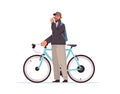 male cyclist taking break during bike ride man with takeaway coffee cup standing near bicycle