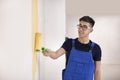 Male decorator painting wall with roller indoors Royalty Free Stock Photo