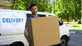Male delivery worker holding big box, fast packages delivery to home, service