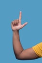 Male demonstrating a finger gun gesture isolated over the blue background Royalty Free Stock Photo