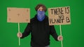A male demonstrator with his face covered by a scarf holds up a sign that says There is no planet B and a blank sign