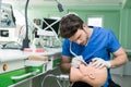 Male dental student practicing on doll.