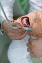 Male dental student practicing on doll.